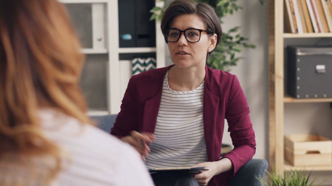 Mid-shot of a Psychologist talking to their client.